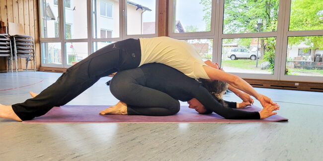Zwei Frauen die eine Yogaübung ausführen
